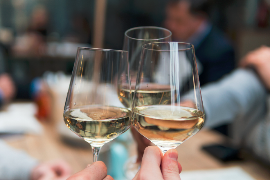 Amis en train de trinquer avec des verres de vin blanc